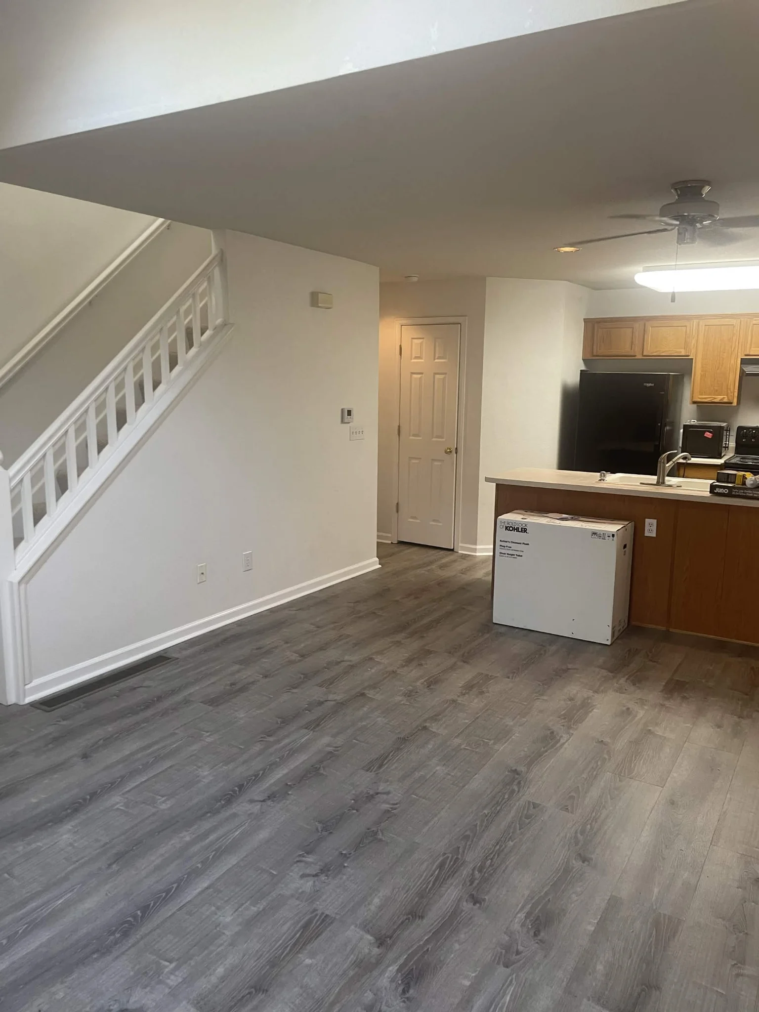 L&E Construction completed project — open living room with hardwood flooring and custom staircase